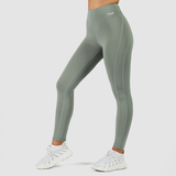 a fit woman stand at right and wearing legging green with logo and shoes white ,the  background is light grey 