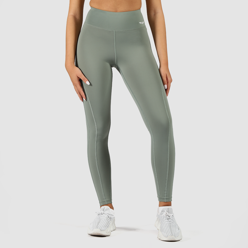 a fit woman wearing legging green with logo and shoes white ,plus the background is light grey 