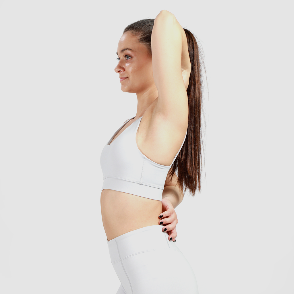  a woman wearing matching bra  and legging with background light grey 