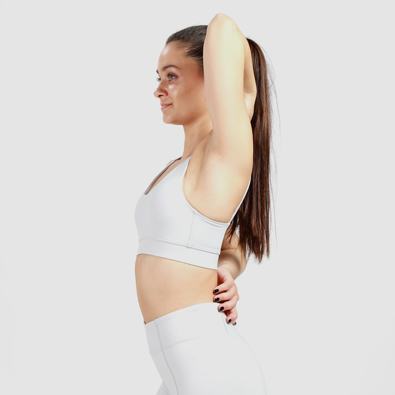  a woman wearing matching bra  and legging with background light grey 