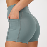 close up view  for fit  woman wearing short with pocket ,plus the background is light grey 