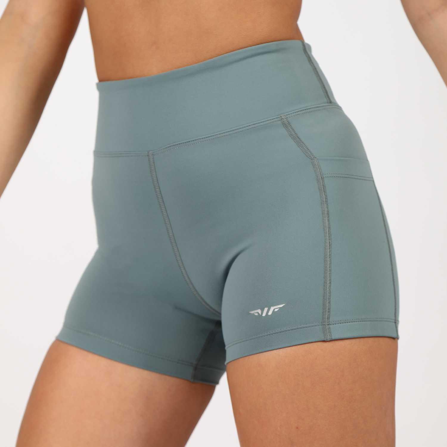 a fit woman wearing short blue with logo ,plus the background is light grey 