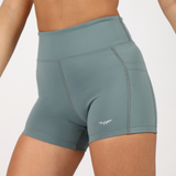 a fit woman wearing short blue with logo ,plus the background is light grey 