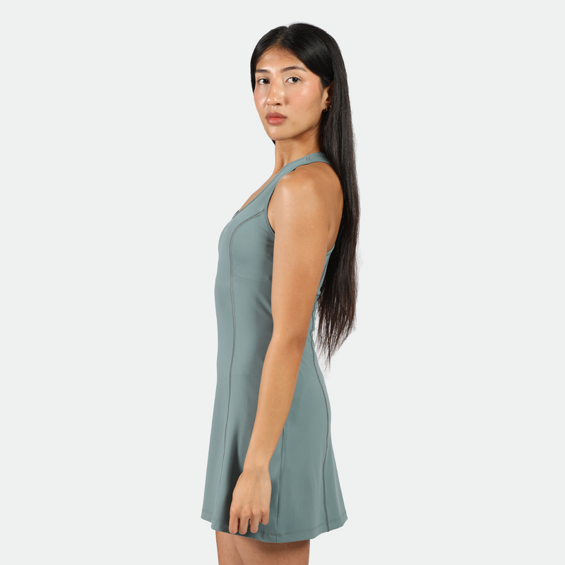 a fit woman stand at right and wearing  dress green 