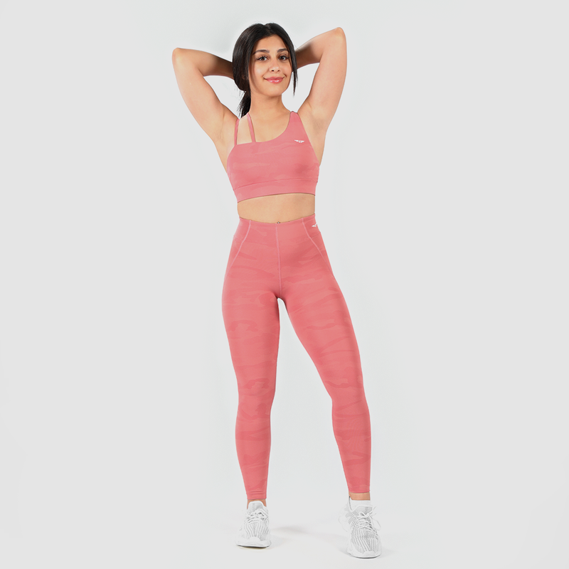 a fit woman wearing matching camo orange bra and legging ,plus the background is light grey 