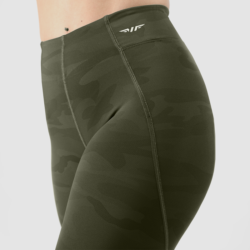 a fit woman wearing olive camouflage with logo white ,plus the  background is light grey 