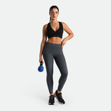 a fit woman wearing bra black and legging grey ,plus the shoes black 