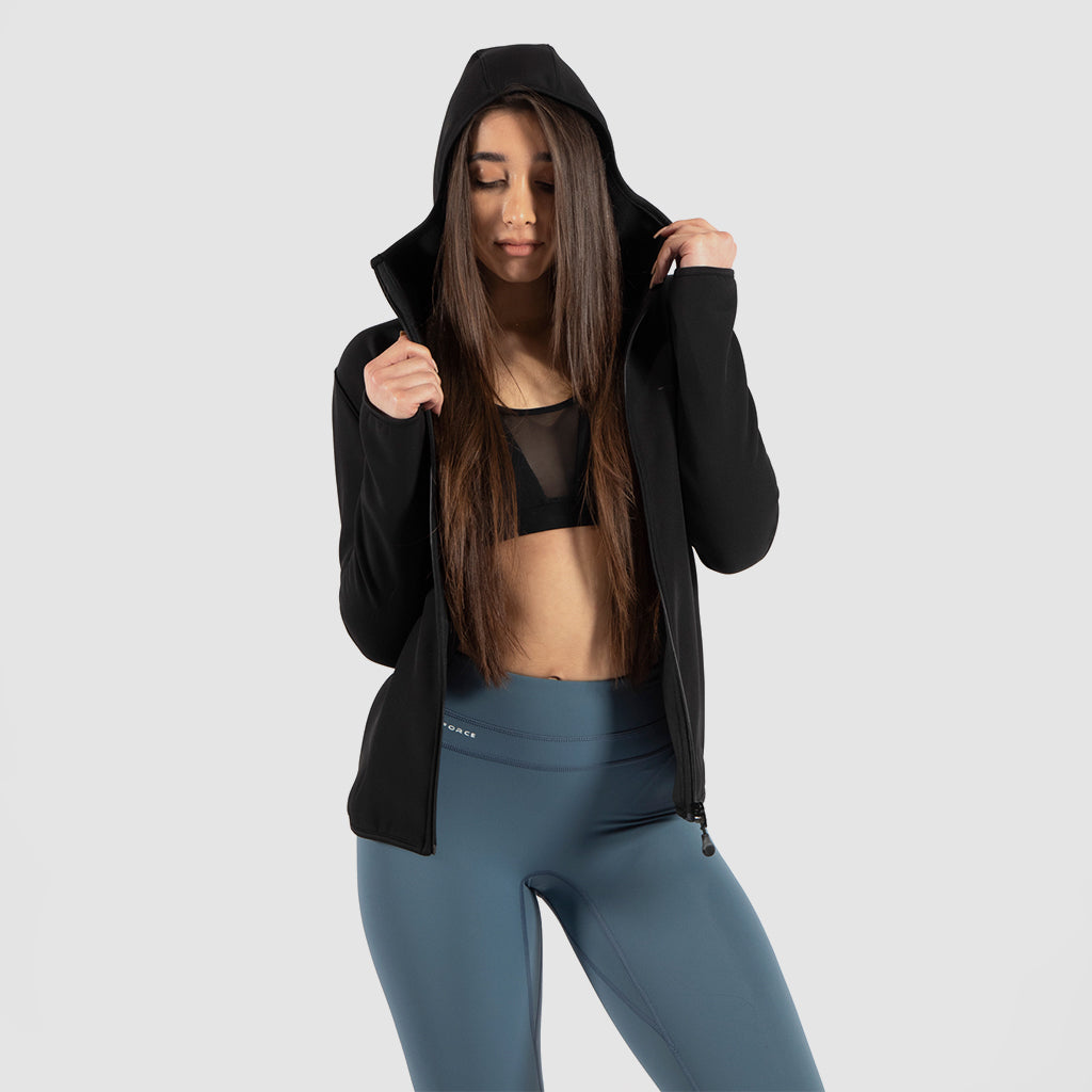 a fit woman wearing jacket black with  bra black and legging green