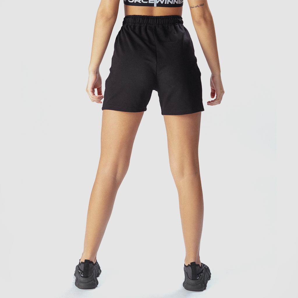 a back view or fit woman wearing short black with shoes ,plus the background is light grey 