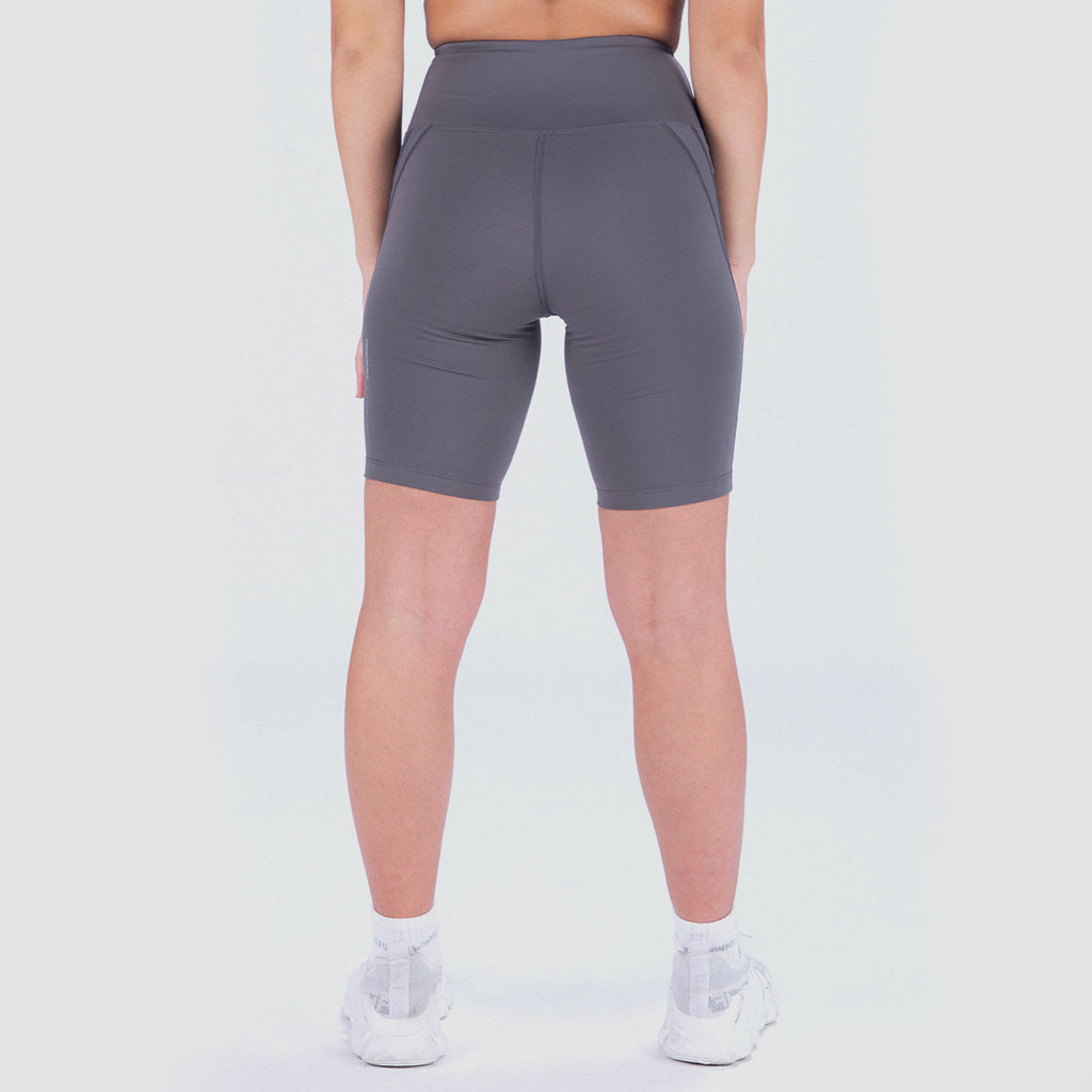 a back view for fit woman wearing seamless short grey with shoes white ,plus the background is light grey 
