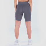 a back view for fit woman wearing seamless short grey with shoes white ,plus the background is light grey 