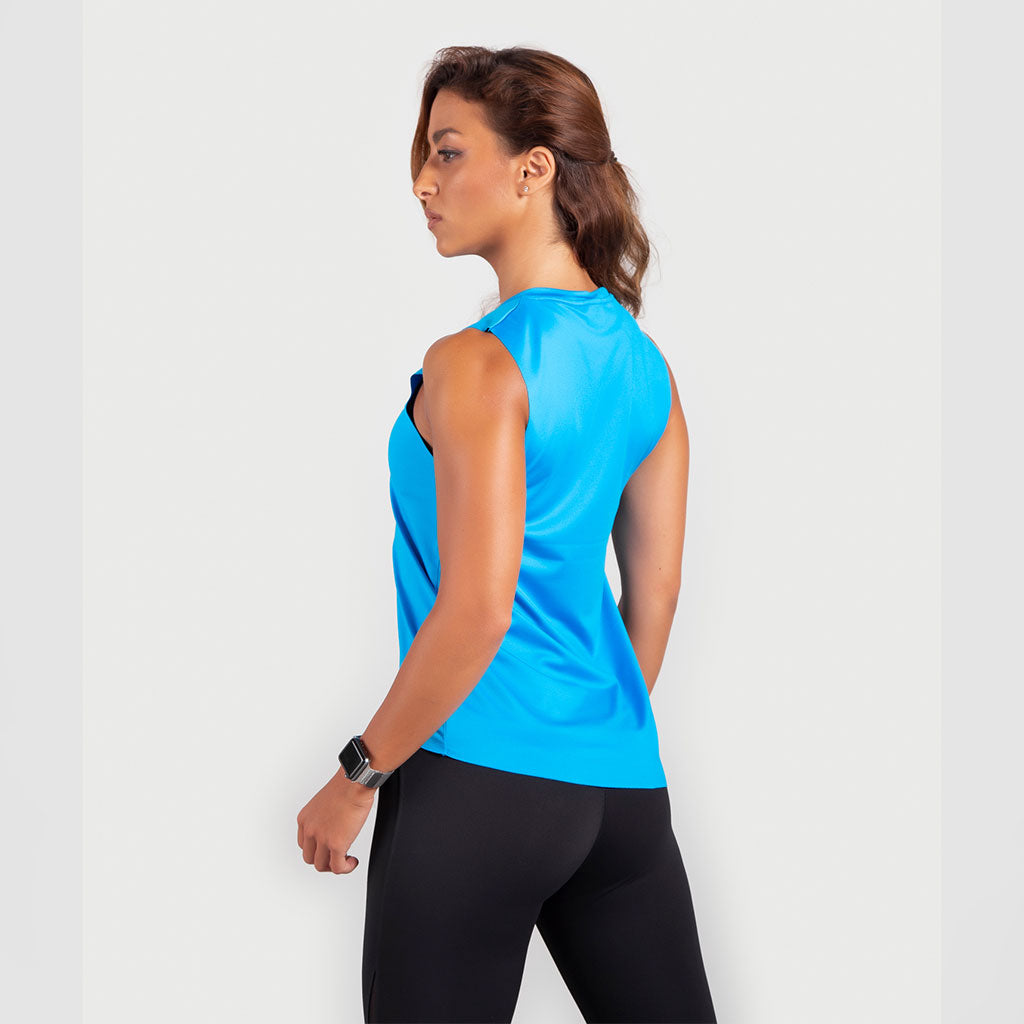 a fit woman stand at right and wearing  tank blue with legging black 