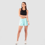 a fit woman wearing sport bra black and short sky blue with shoes white ,plus the background is light grey 