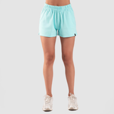 a fit woman wearing sky blue short  with shoes white ,plus the background is light grey 