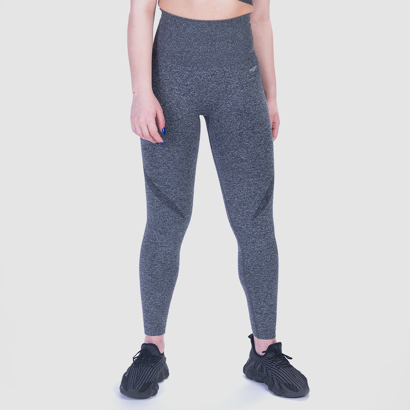 a fit woman wearing legging grey  with logo and shoes ,the background is light grey 