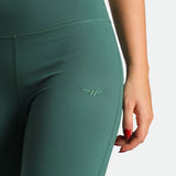 close up view for fit woman wearing flared legging posy green with logo 