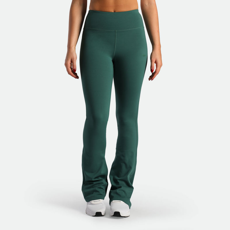 a fit woman wearing flared legging posy green with shoes white 
