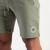 Close-up of green shorts with a logo 