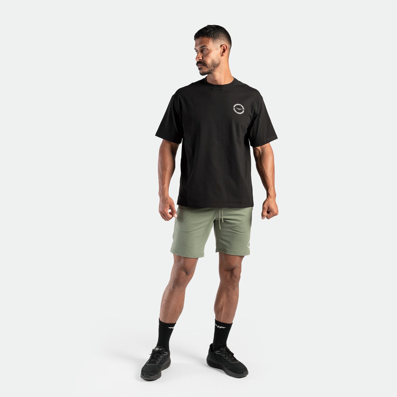 Man wearing a black t-shirt and green shorts ,plus the socks and short  black 