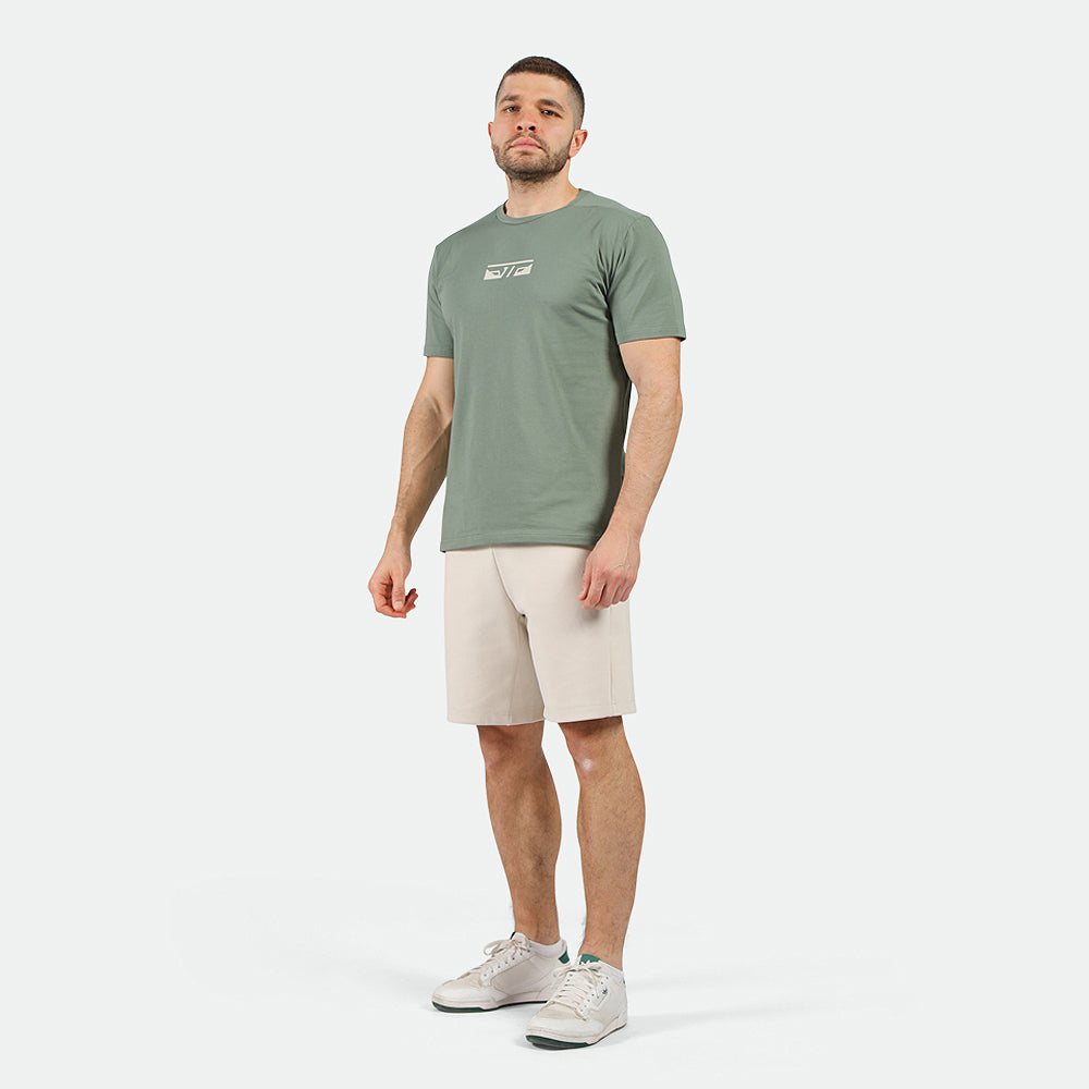 a fit man wearing t-shirt agave green with short beige 