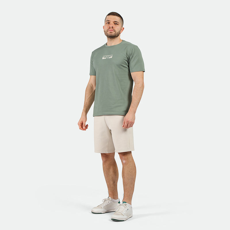 a fit man wearing t-shirt agave green with short beige 
