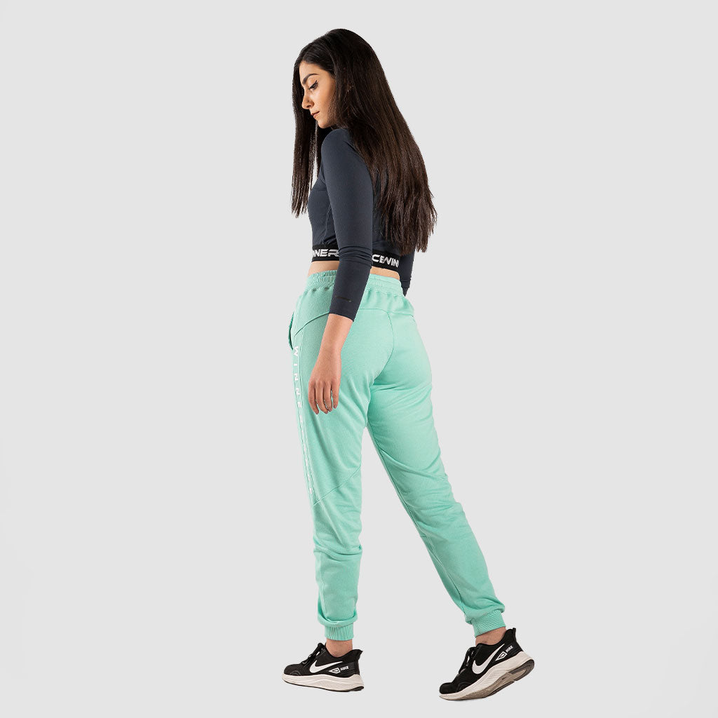 a back view for fit woman wearing crop top black with pants  aqua and  sneakers black 