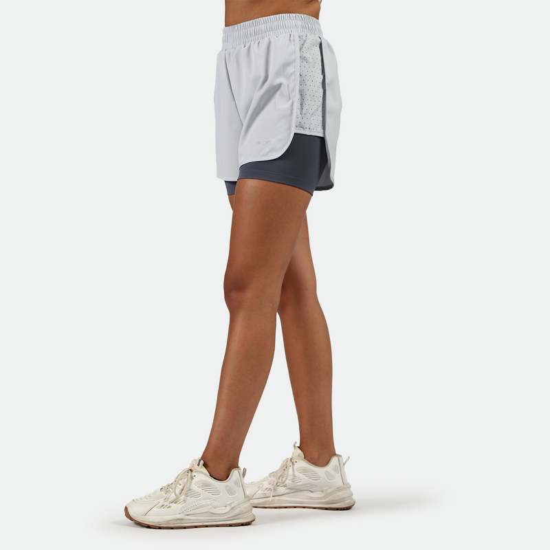 a fit woman stand at right and wearing 
  arctic ice blue short  with shoes white  plus the background is light grey 