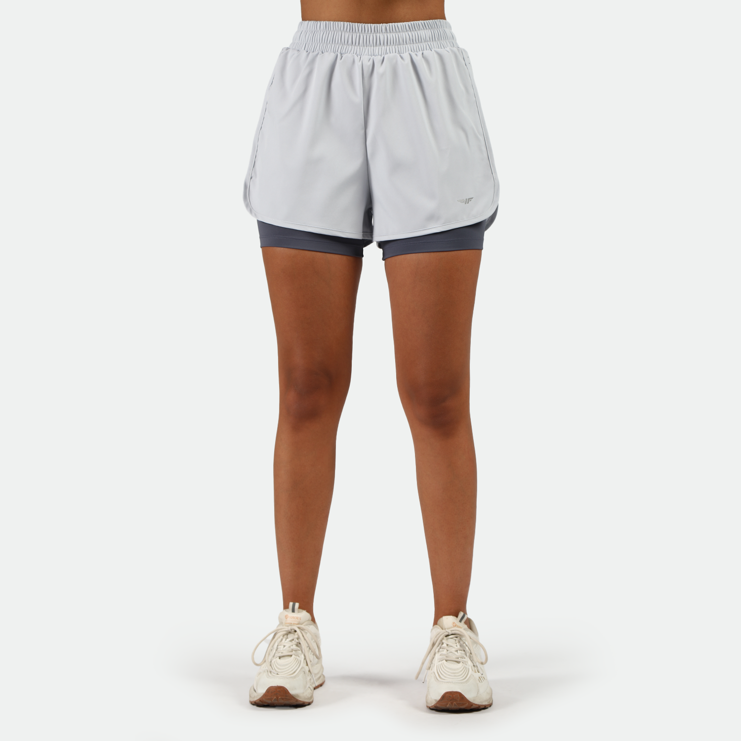 a fit woman wearing  arctic ice blue  short 2 in 1 with shoes white ,plus the background is light grey 