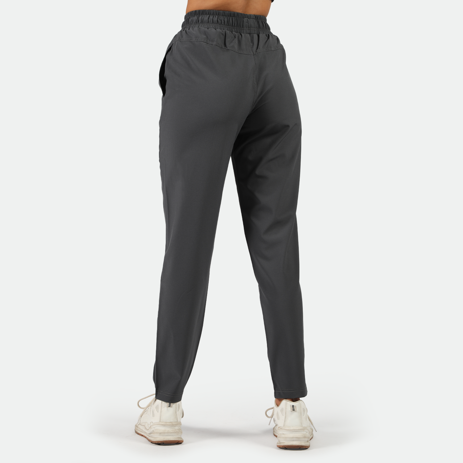 a back view for fit woman wearing shoes white ,plus the background is light grey 