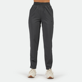 a fit woman wearing pant grey with white athletic shoes ,plus the background is light grey  