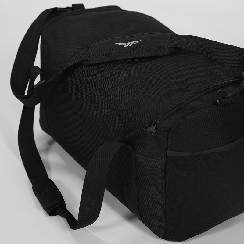 Black duffel bag with reinforced shoulder strap and zipper pocket on white background. Minimalist design with subtle logo, conveying functionality.