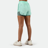 a back view for fit woman wearing  beach glass blue with shoes white ,plus the background is light grey 