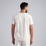 a fit man stand at lift and wearing t-shirt white with pants white 