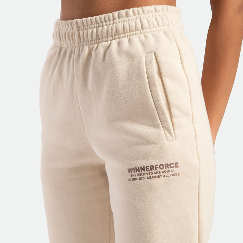 close up view for pocket beige of pant with logo brown ,plus the background is light grey 