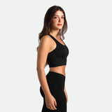 a fit woman stand at right  and wearing  matching set  black ,crop top and legging 