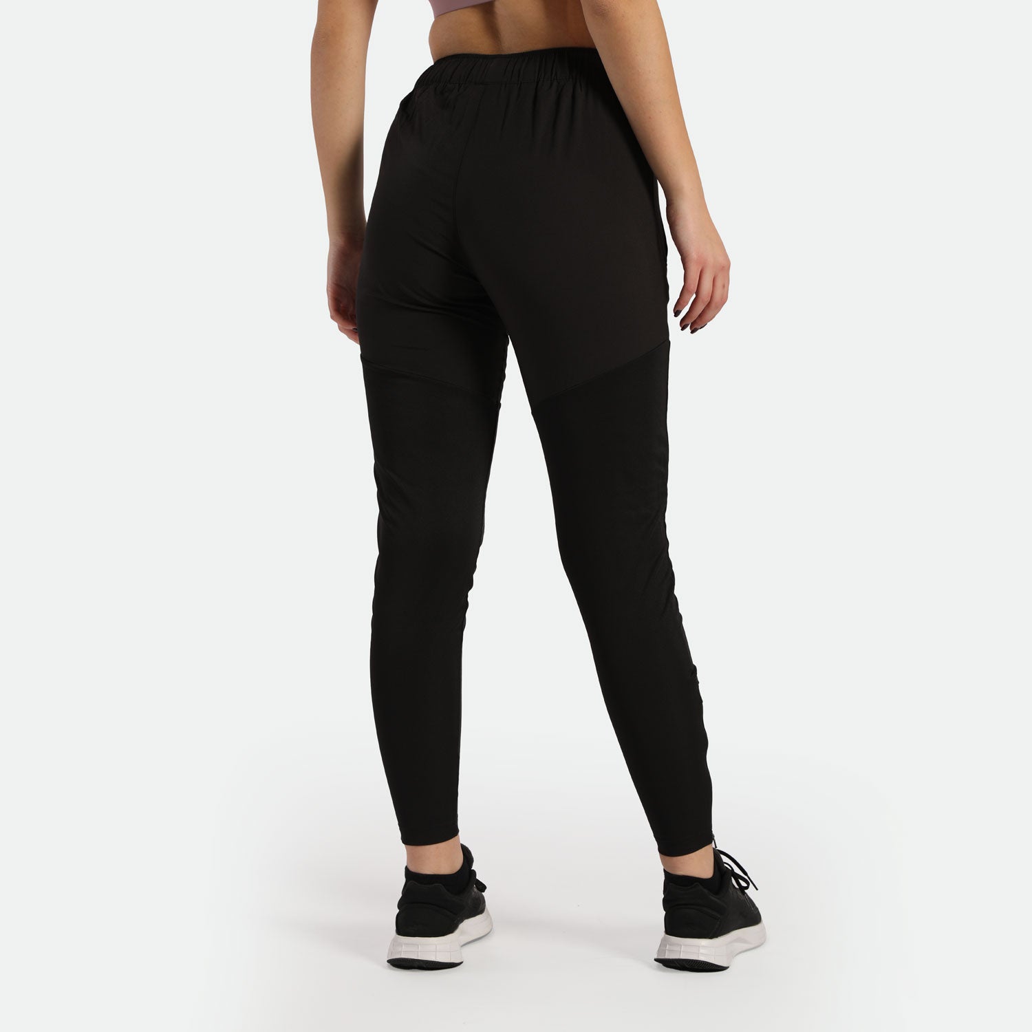 a back view for fit woman wearing pants black with sneakers 