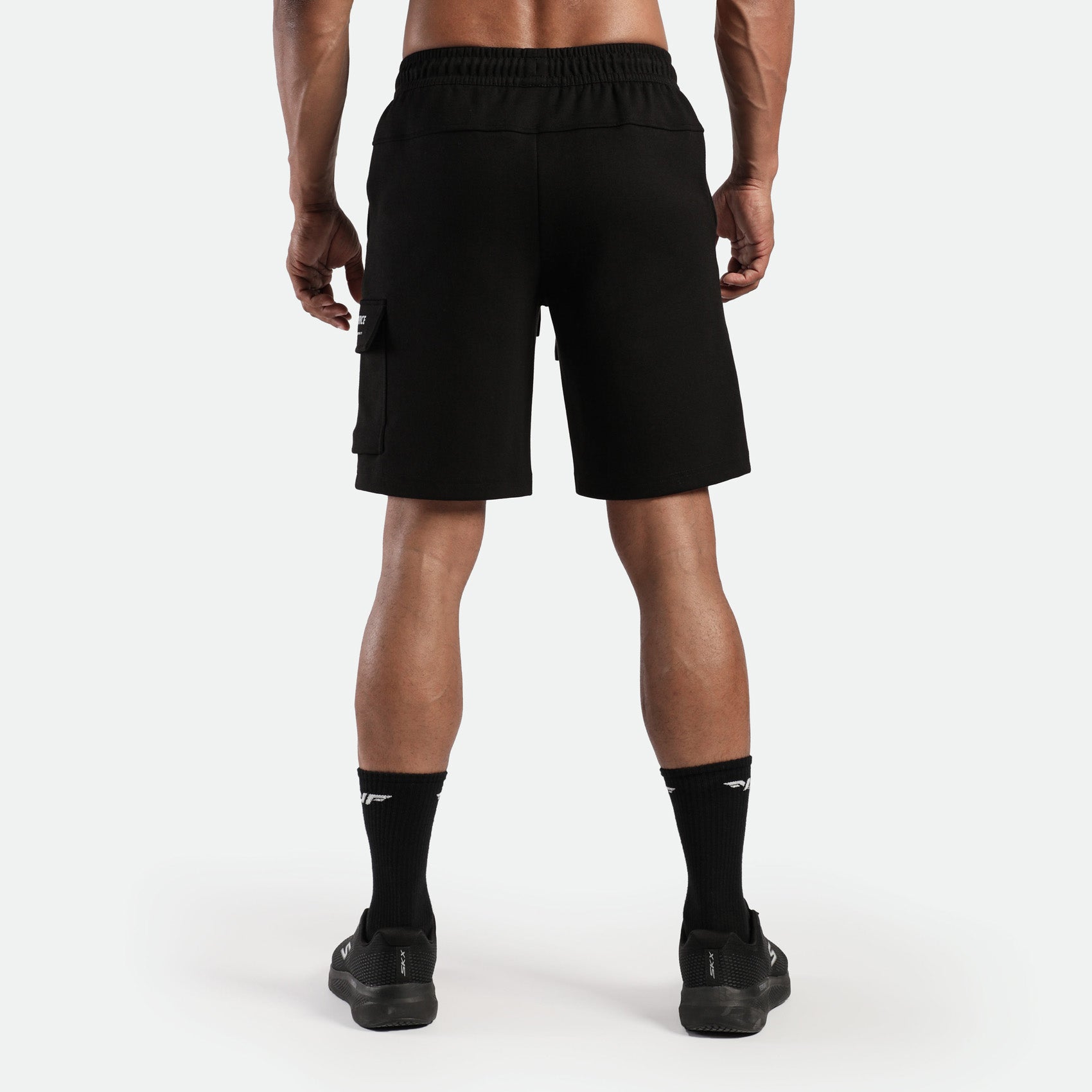 a back view for fit man wearing short with socks and shoes black 