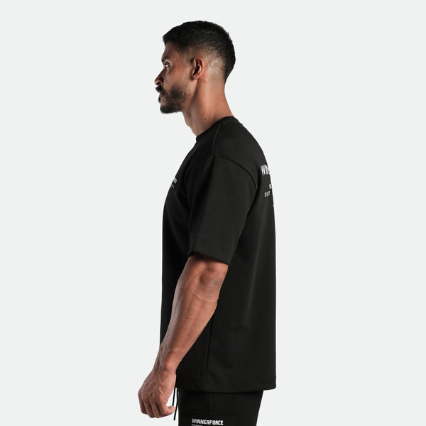 a fit man stand at right and wearing  matching set black t-shirt and short 