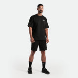 a fit man wearing matching set black  t-shirt and short , plus he wearing socks  and shoes black 