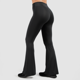 a back view for fit woman wearing flared legging and shoes black ,plus the background is light grey 
