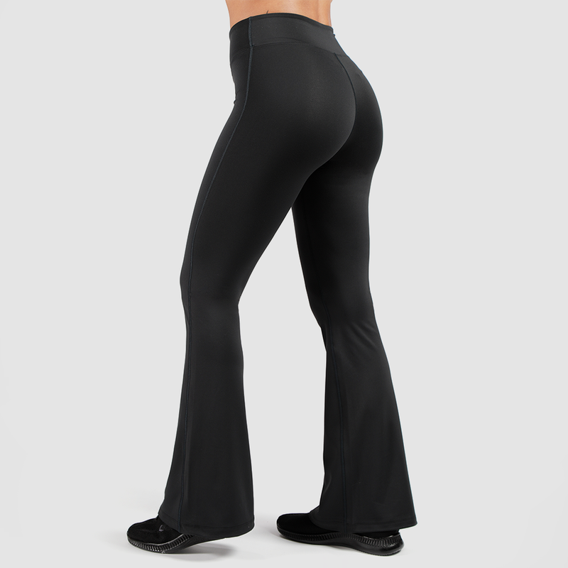 a back view for fit woman wearing flared legging and shoes black ,plus the background is light grey 
