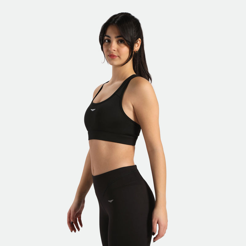 A woman in athletic wear, featuring a black sports bra and matching high-waisted leggings, have same logo  but different direction 