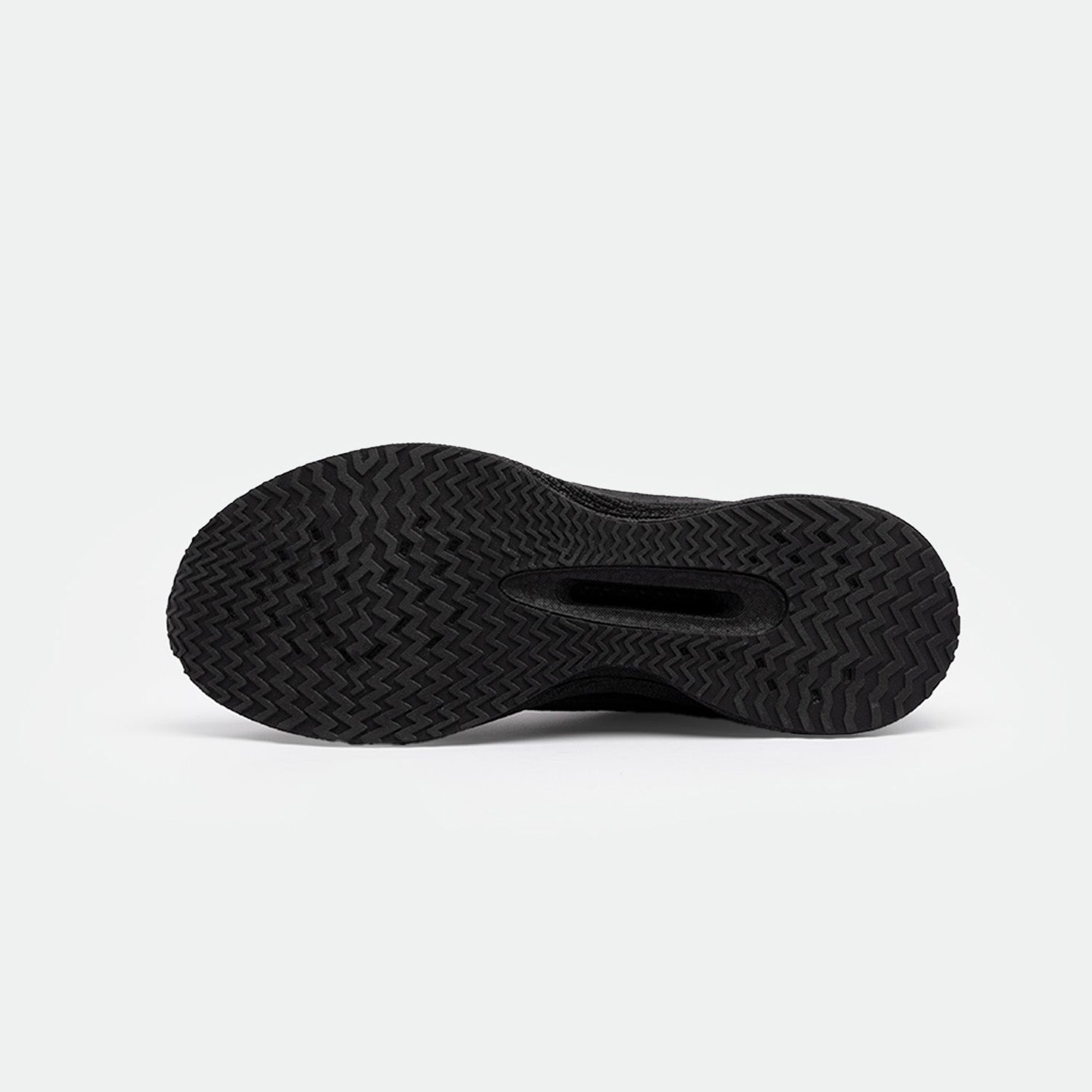 The image shows the black sole of a shoes with a textured herringbone pattern, emphasizing grip. The background is white, highlighting the details clearly.