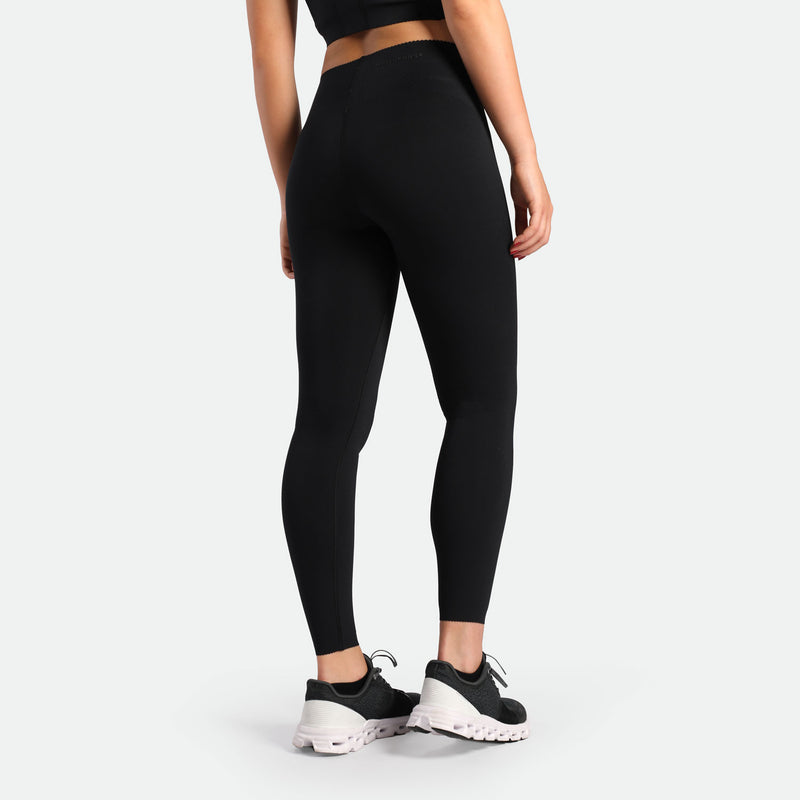 a back view for fit woman wearing legging  black with shoes black 