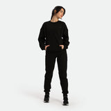 a fit woman stand with pose and wearing  matching black sweatshirt with pants black 