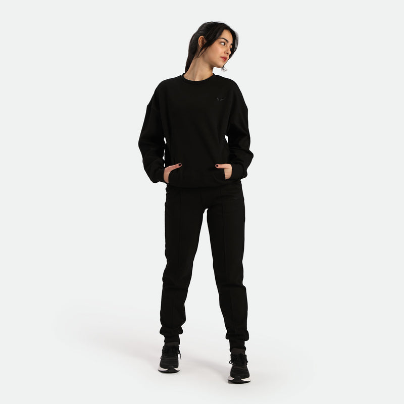 a fit woman stand with pose and wearing  matching black sweatshirt with pants black 