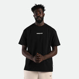 a fit man stand with confidence and look at the camera ,he wearing t-shirt black with short beige