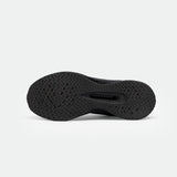 The image shows the sole of a black sneaker with a textured, herringbone pattern, providing traction. The tone is sleek and functional on a neutral background.