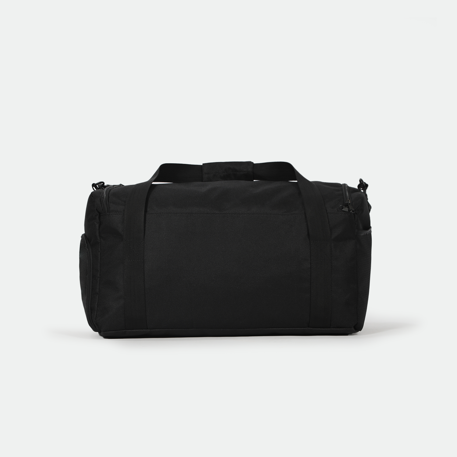A black duffel bag with sturdy handles and a textured surface is centered against a plain white background, conveying simplicity and functionality.