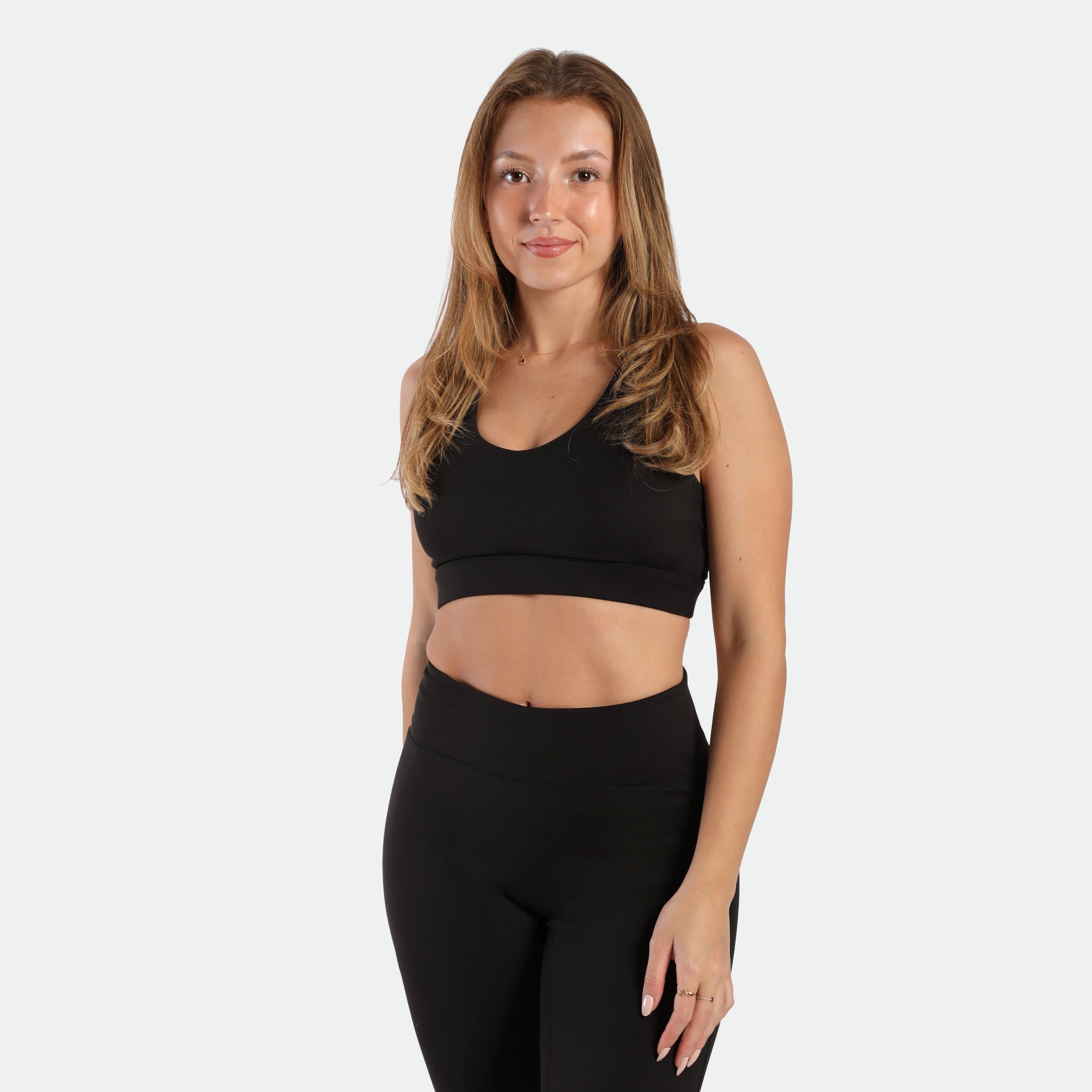 a fit woman wearing matching set black , bra and legging 